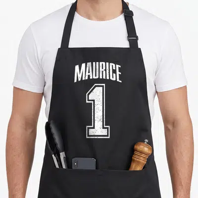 Tablier de cuisine noir avec inscription blanche Maurice et grand chiffre 1 style maillot de sport délavé.