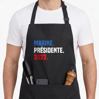 Tablier de cuisine noir avec l'inscription MARINE. PRÉSIDENTE. 2022. en bleu blanc et rouge.