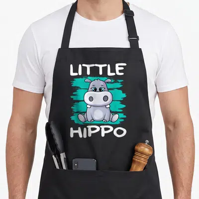 Tablier de cuisine noir avec un hippopotame cartoon gris et des mots Little Hippo en blanc.