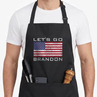 Tablier de cuisine noir avec le drapeau américain et le texte Let's Go Brandon imprimé en blanc sur le devant.