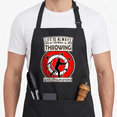 Tablier de cuisine noir avec une silhouette tirant des haches sur une cible rouge et blanche.