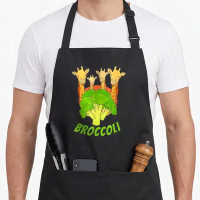 Tablier de cuisine noir avec illustration de quatre girafes et un brocoli vert portant l'inscription Broccoli en bas.
