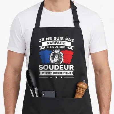 Tablier de cuisine noir avec illustration d'une soudeuse et texte blanc sur fond de carte de France bleue et rouge.