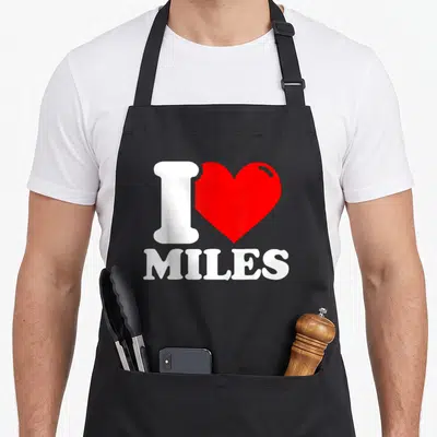 Tablier de cuisine noir avec un grand cœur rouge et le texte I love Miles en blanc.