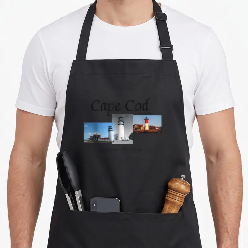 Tablier de cuisine noir avec collage de phares Cape Cod et inscriptions America's Best History National Seashore