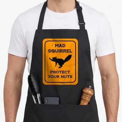 Tablier de cuisine noir avec un panneau orange affichant un écureuil et le texte Mad Squirrel Protect Your Nuts.