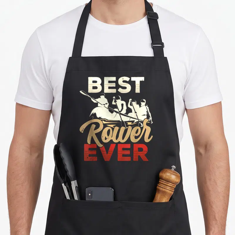 Tablier de cuisine noir avec inscription Best Rower Ever et silhouettes d'avirons vintage beige et rouge.