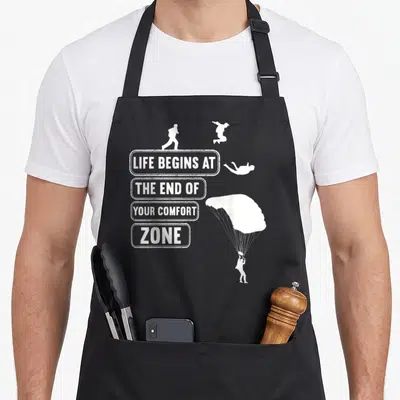 Tablier de cuisine noir avec texte blanc et silhouettes de parachutistes en chute libre.