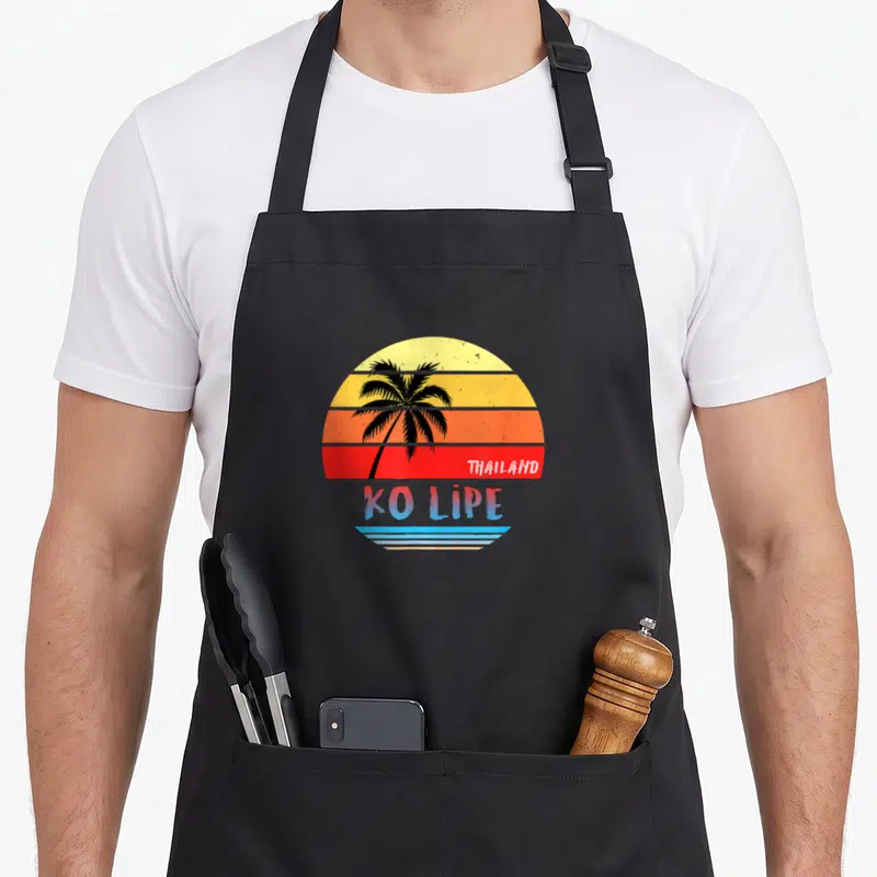 Tablier de cuisine noir avec un soleil couchant vintage illustrant Ko Lipe Thaïlande et un palmier noir.