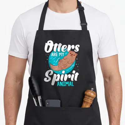 Tablier de cuisine noir avec une illustration de loutre de mer et le texte Otters Are My Spirit Animal en blanc et bleu.