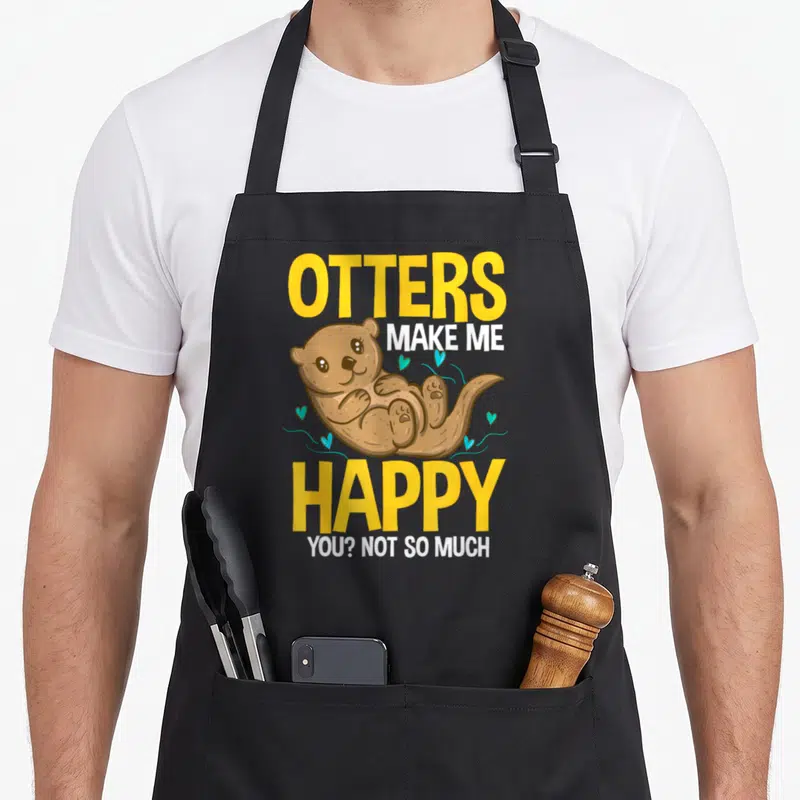 Tablier de cuisine noir avec illustration de loutre et texte Otters Make Me Happy You Not So Much en jaune et blanc.