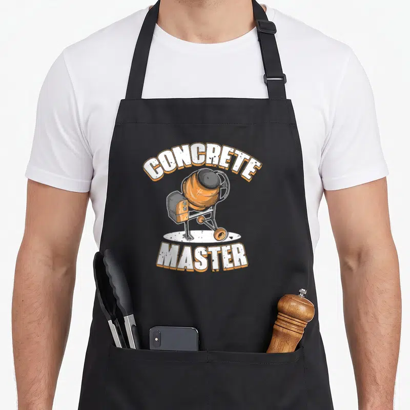 Tablier de cuisine noir avec illustration de bétonnière orange et texte White Concrete Master en arc de cercle.