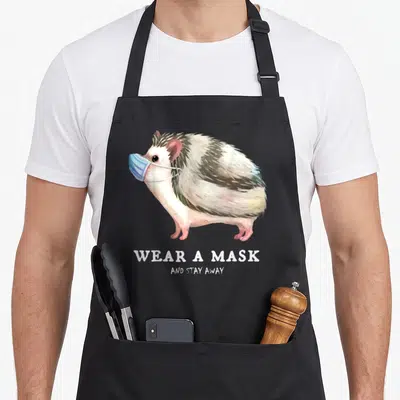 Tablier de cuisine noir avec illustration d'un hérisson portant un masque bleu et du texte en anglais.