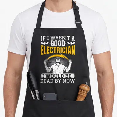 Tablier de cuisine noir avec illustration d'un électricien sous arc électrique et texte blanc et jaune.