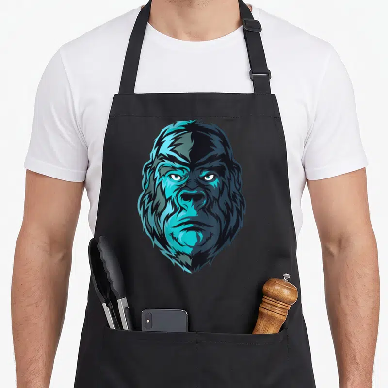 Tablier de cuisine noir avec un grand portrait de gorille aux tons bleus et noirs, style illustration vectorielle.
