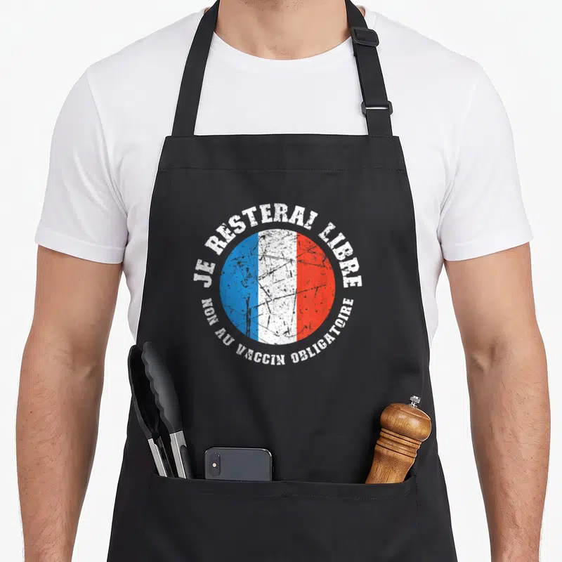 Tablier de cuisine noir avec logo circulaire tricolore et texte blanc Je resterai libre non au vaccin obligatoire.