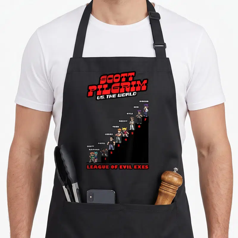 Tablier de cuisine noir avec illustration pixel art de Scott Pilgrim et ses adversaires sur un podium rouge et noir.