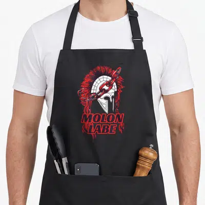 Tablier de cuisine noir avec illustration d'un casque spartain rouge et blanc enchaîné surmonté du texte Molon Labe.