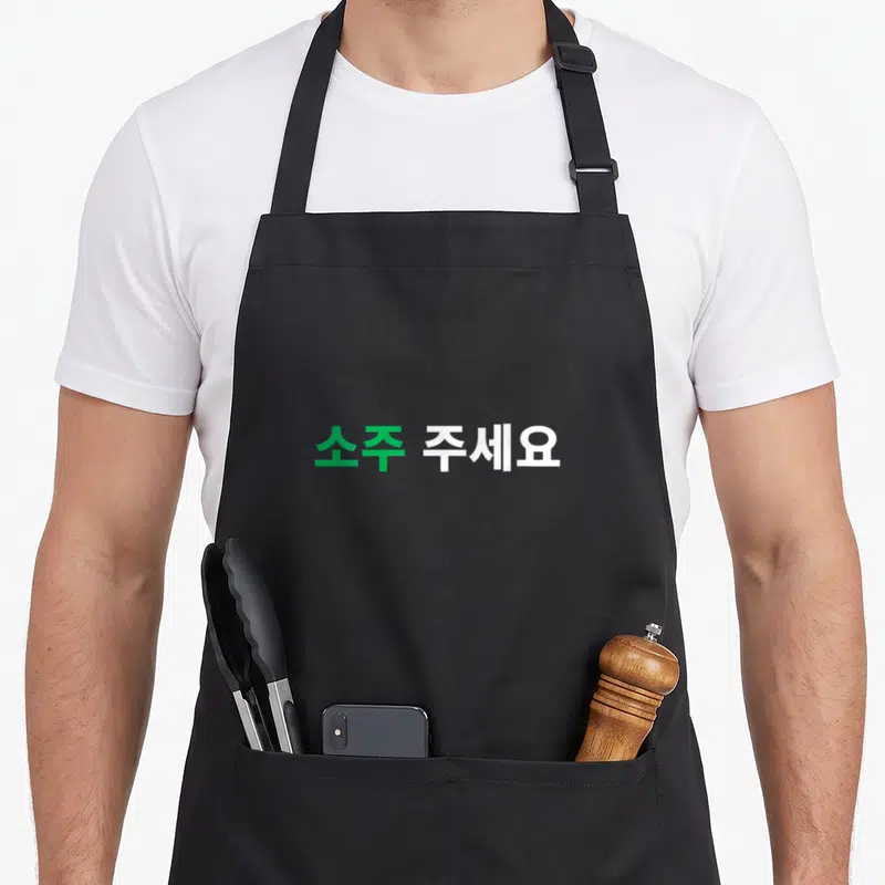 Tablier de cuisine noir avec texte en hangul vert et blanc soju au centre.