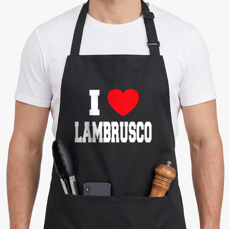 Tablier de cuisine noir avec inscription blanche I Love Lambrusco et un grand cœur rouge au centre du motif imprimé.