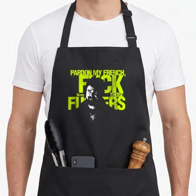 Tablier de cuisine noir avec l'inscription Pardon My French Fuck Those F*ckers et un portrait stylisé en jaune fluo.