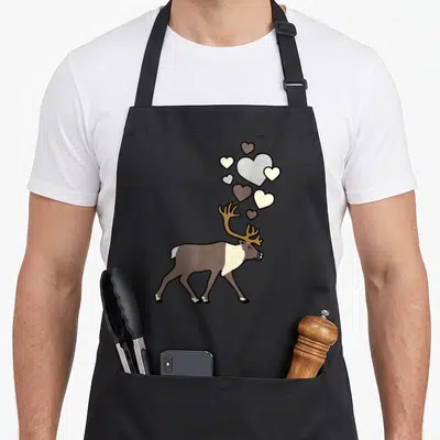 Tablier de cuisine noir avec un caribou mignon et des cœurs flottants au-dessus de ses bois.
