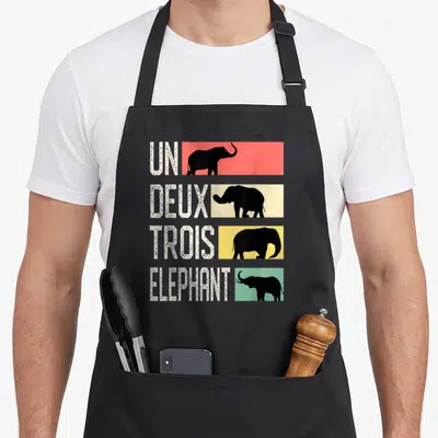 Tablier de cuisine noir avec quatre bandes colorées affichant des éléphants noirs et le texte Un Deux Troix Elephant en blanc.