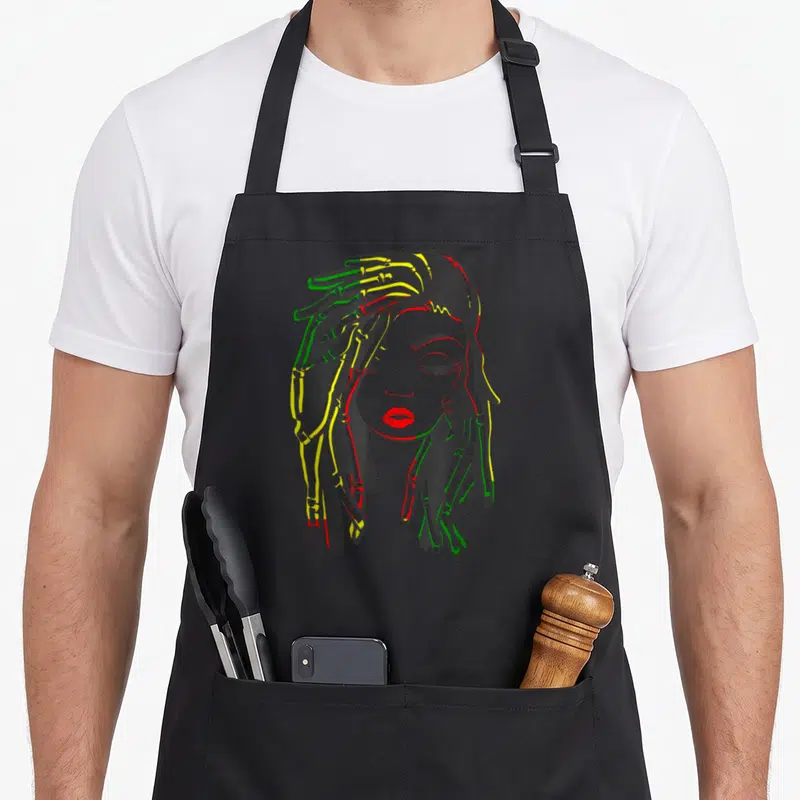 Tablier de cuisine noir avec illustration d'une femme aux dreadlocks aux couleurs vert jaune et rouge.