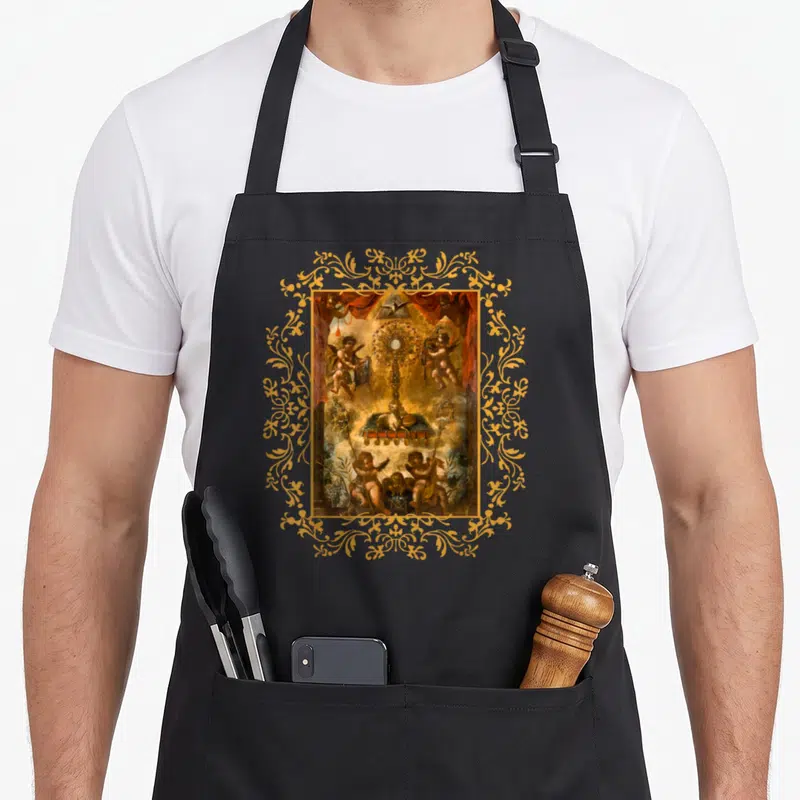 Tablier de cuisine noir avec une illustration religieuse représentant un ostensoir entouré d'anges et encadré de motifs dorés.