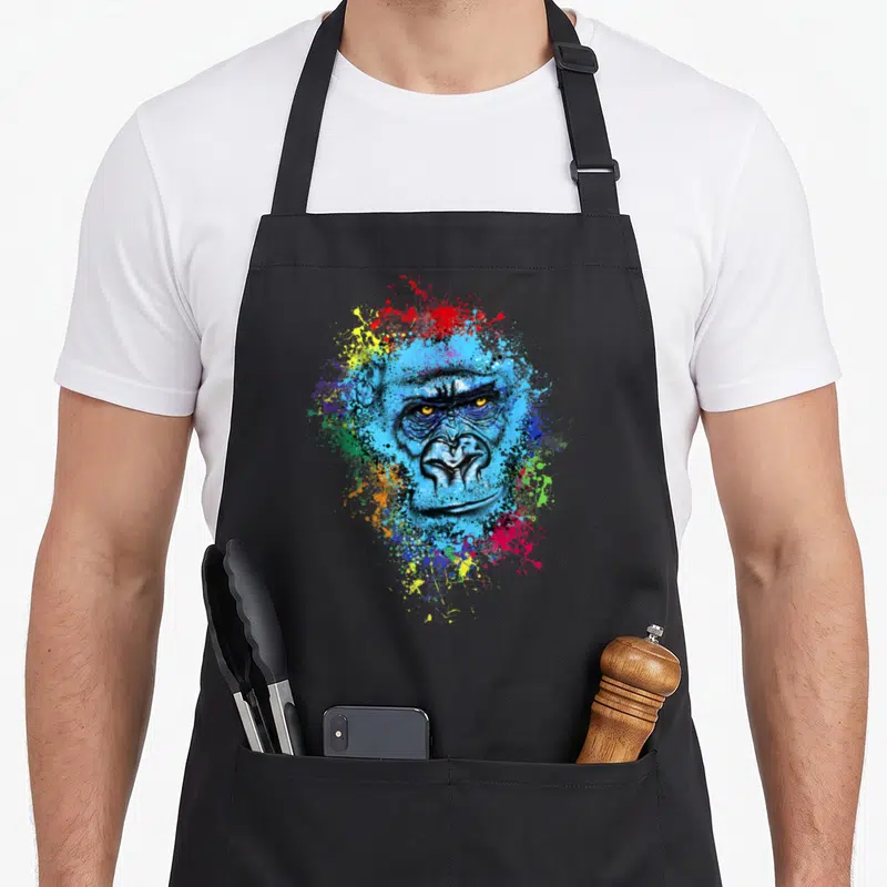Tablier de cuisine noir avec illustration colorée d'un gorilla aux éclats peints et regards perçants.