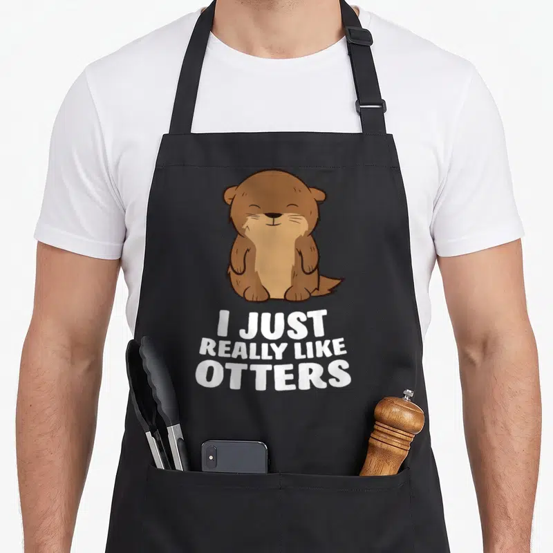 Tablier de cuisine noir avec illustration d'un loutre souriant et texte blanc I Just Really Like Otters