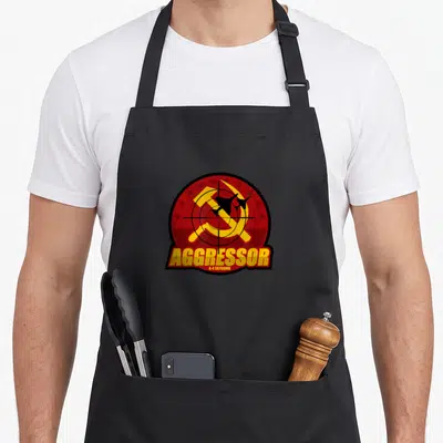 Tablier de cuisine noir avec le logo circulaire Aggressor A-4 Skyhawk en rouge et jaune.