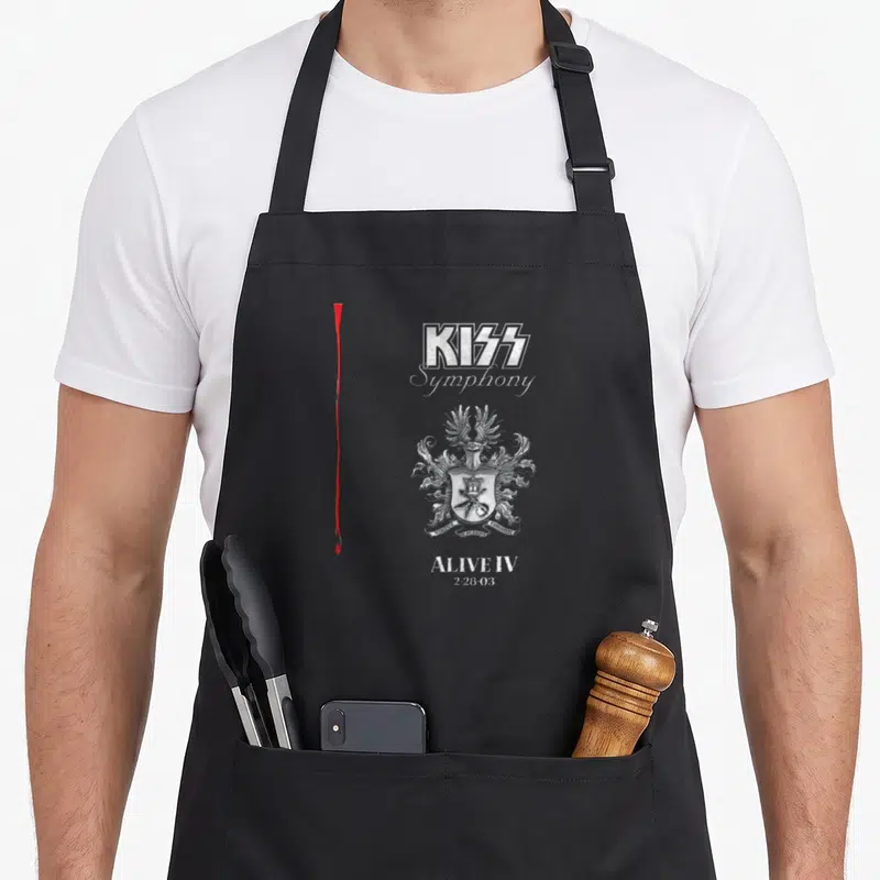 Tablier de cuisine noir avec le logo KISS Symphony, un écusson détaillé et la date 228 03 imprimés en blanc.