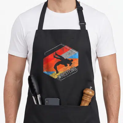 Tablier de cuisine noir avec silhouette de lutteur et le mot WRESTLING sur fond hexagonal coloré.