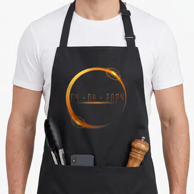 Tablier de cuisine noir avec un cercle orange lumineux et la date 04.08.2024 au centre.