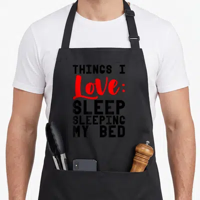Tablier de cuisine noir avec inscription Things I Love Sleep Sleeping My Bed en noir et rouge.