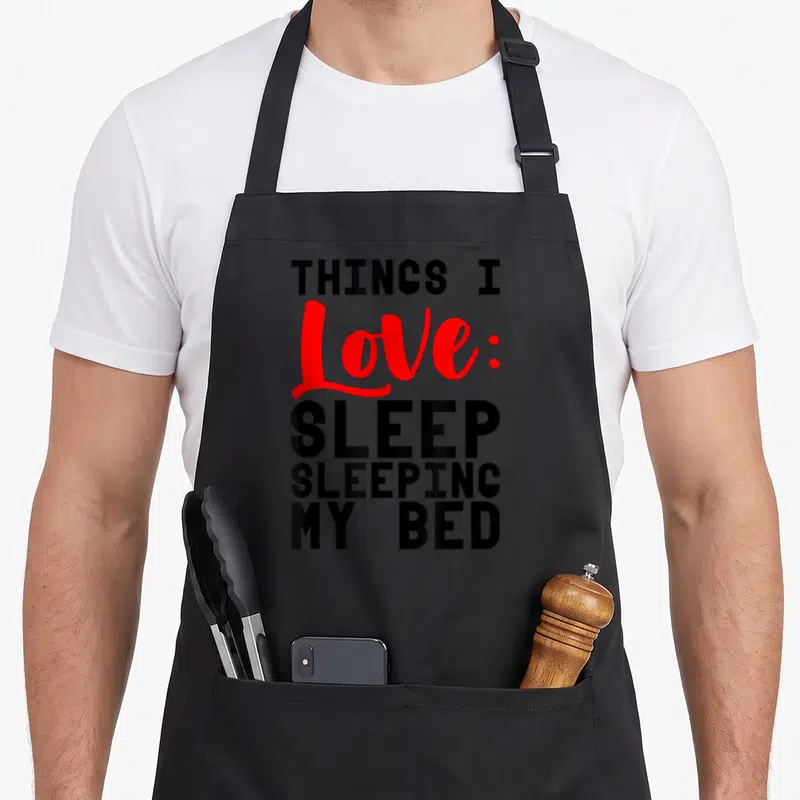 Tablier de cuisine noir avec inscription Things I Love Sleep Sleeping My Bed en noir et rouge.