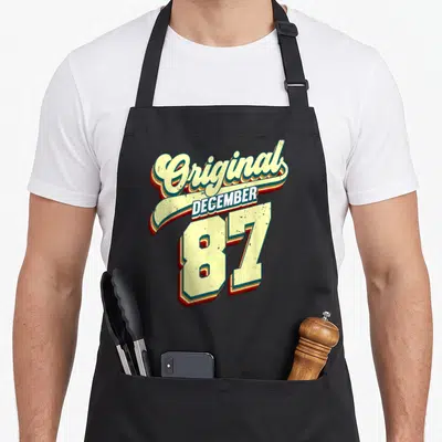 Tablier de cuisine noir avec inscription Original December 87 style vintage rétro couleur crème et rouge.