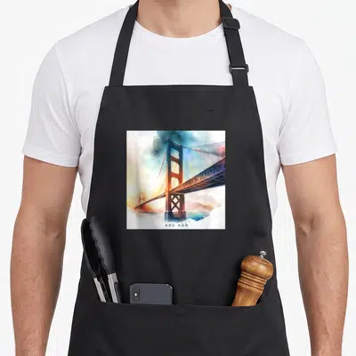 Tablier de cuisine noir avec illustration du pont de San Francisco traversant un brouillard aux teintes chaudes et froides.