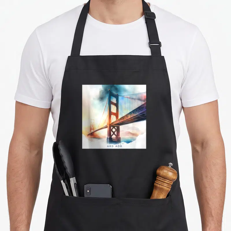 Tablier de cuisine noir avec illustration du pont de San Francisco traversant un brouillard aux teintes chaudes et froides.