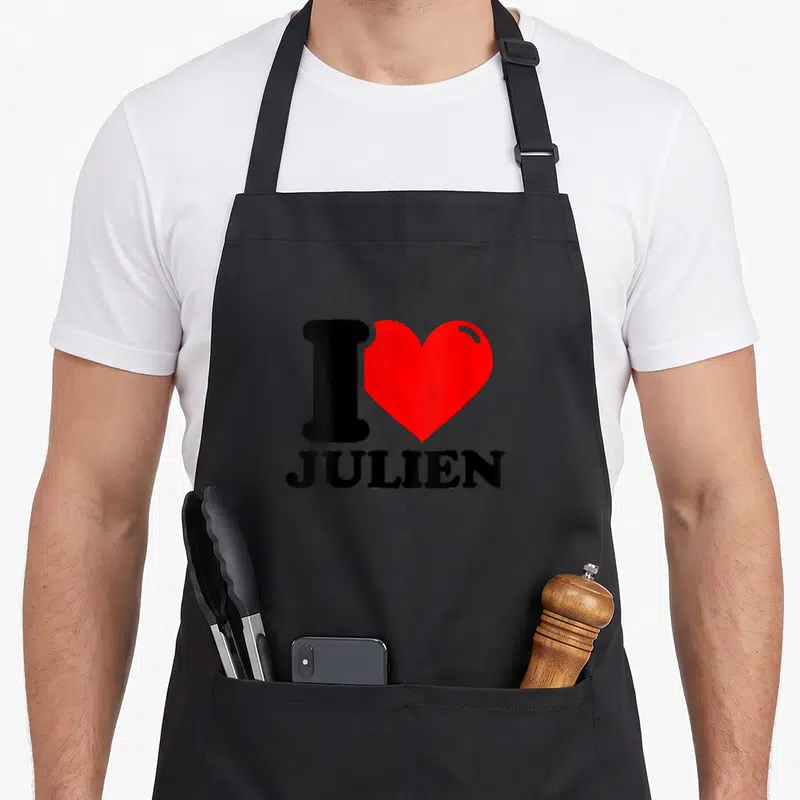 Tablier de cuisine noir avec un grand cœur rouge et le texte I love Julien en lettres noires au centre.