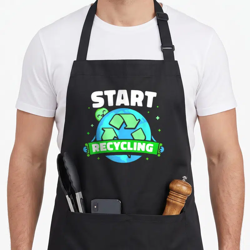 Tablier de cuisine noir avec illustration colorée de la Terre et le texte Start Recycling en lettres blanches.