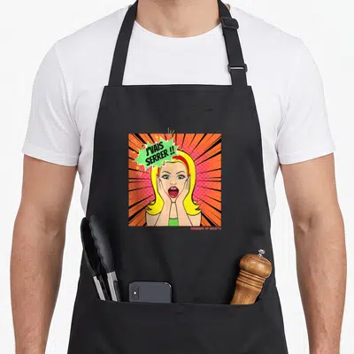 Tablier de cuisine noir avec illustration pop art d'une blonde aux cheveux blonds criant J'VAIS SERRER. sur fond orange rayonnant.