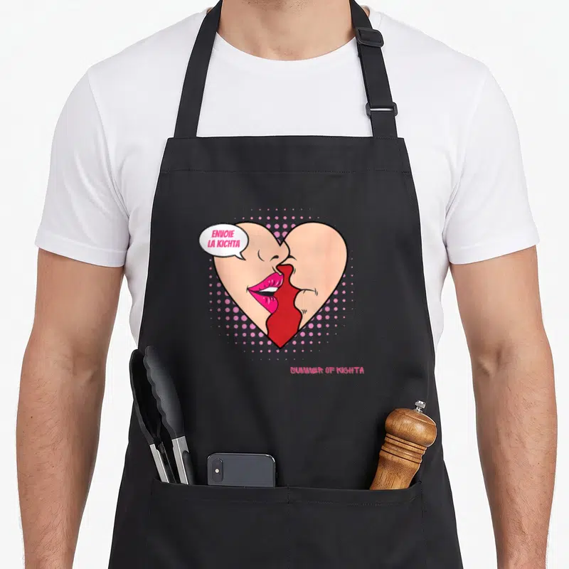 Tablier de cuisine noir avec illustration pop art d'un cœur rose formé par deux lèvres et le texte envoie la kichta.