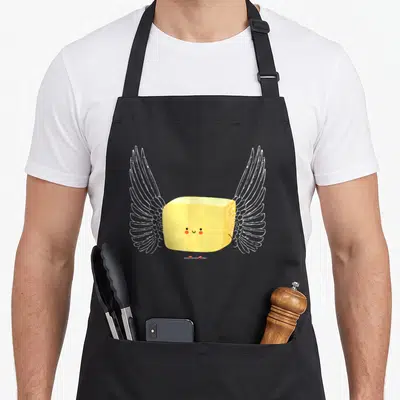 Tablier de cuisine noir avec un bâton de beurre jaune aux grandes ailes blanches et un visage souriant mignon