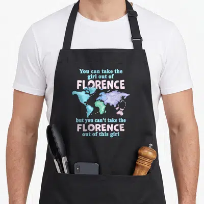 Tablier de cuisine noir avec texte You can take the girl out of FLORENCE et carte du monde colorée.