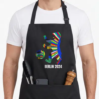 Tablier de cuisine noir avec un ours stylisé aux motifs colorés et l'inscription BERLIN 2024 en bas.