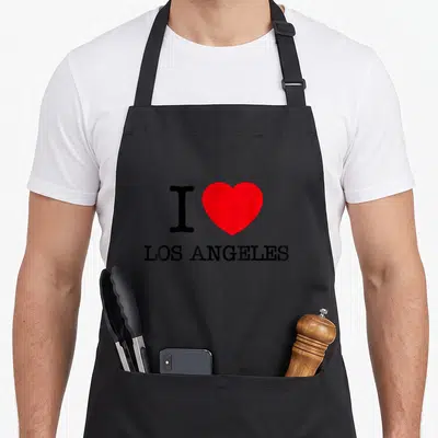 Tablier de cuisine noir avec le logo I Love Los Angeles en noir et rouge centré sur le devant.