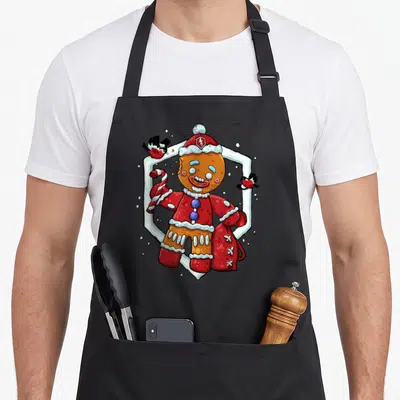 Tablier de cuisine noir avec illustration d'un bonhomme en sucre festif tenant une canne à sucre.