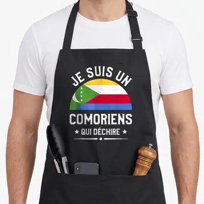 Tablier de cuisine noir avec le drapeau des Comores et l'inscription Je Suis Un Comoriens Qui Déchire Comores en blanc.